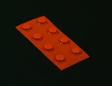 Sheet of 8 medium orange, round, flat top bump dots on black background.